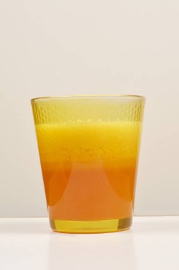 Taze sıkılmış portakal suyuyla dolu bir bardakta renk değişimi görülüyor.
