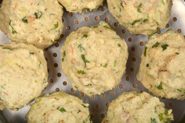 Görünür yeşil otlu ekmek hamuru, pişirilmeye hazır metal buhar tenceresinde dinleniyor.