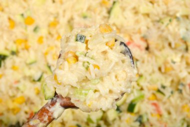 Tahta kaşıkta kremalı sebzeli risotto, kabak, mısır ve kırmızı biber içeren yakın plan.