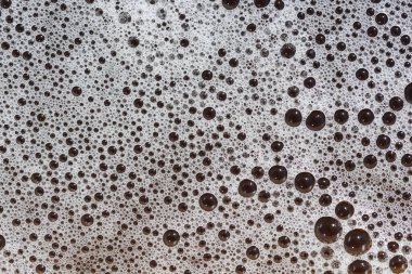 Değişen boyutlarda köpük kabarcıklarının yakın plan görüntüsü soyut bir doku oluşturur.