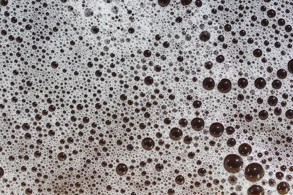 Değişen boyutlarda köpük kabarcıklarının yakın plan görüntüsü soyut bir doku oluşturur.