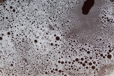 Değişen boyutlarda köpük kabarcıklarının yakın plan görüntüsü soyut bir doku oluşturur.