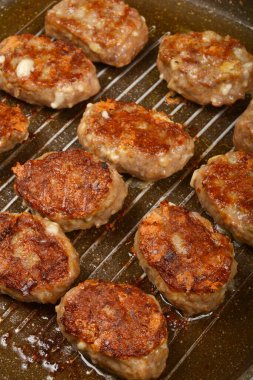 Yakın plan, tepeden çekimde leziz kıymalı ve peynirli börekler pişerken ızgarada kahverengileşiyorlar.