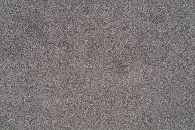 Dış cephe dokusunun yakın çekimi granüler, gri bir yüzeyi gösteriyor.