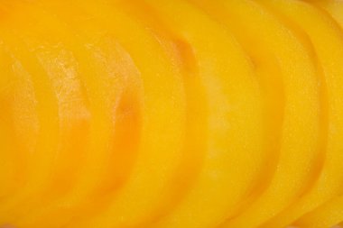 Dilimlenmiş haşlanmış patatesin yakın çekimi, canlı sarı rengini ve katmanlı dokusunu gözler önüne seriyor.