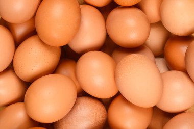 Bir sürü kahverengi tavuk yumurtasının yakın çekimi, tüm çerçeveyi dolduruyor.