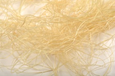 Yakın plan, hassas, açık renkli mısır ipeğinden oluşan karmakarışık bir kütleyi ortaya çıkarır.