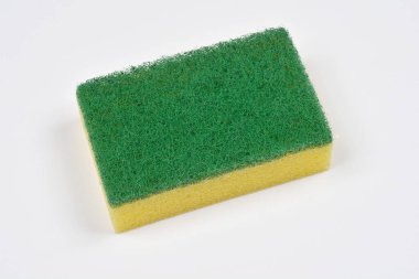Beyaz bir yüzeye yeni, sarı ve yeşil bir sünger sürüyorum.