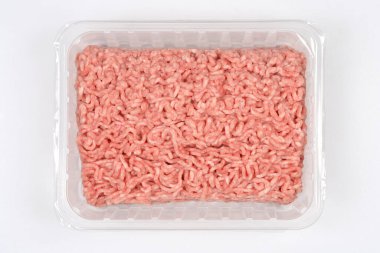 Tarafsız bir zeminde pişmeye hazır taze domuz eti ve sığır eti paketi.