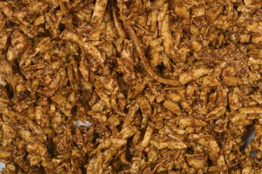 Soya soslu ve hardallı füme tofu yığını desenli kahverengi bir zemin oluşturur.