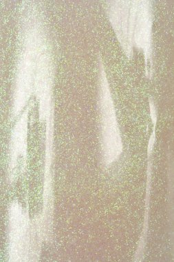 Yakın çekim, plastik bir şişenin içindeki yanardöner sim yapıştırıcının dokusunu ve parıltısını gösterir.