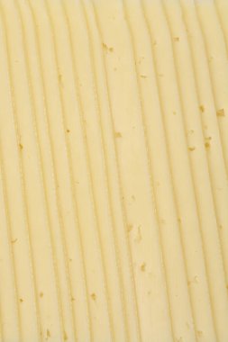 Yakın çekim, istiflenmiş peynir dilimlerinin dokusunu, dikey çizgiler oluşturarak gösterir.