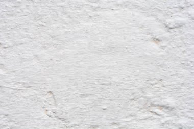 Yıpranmış, pürüzlü ve desenli bir yüzeyi olan, yaşı ve kusurları gösteren, yıpranmış, beyaz bir duvar.