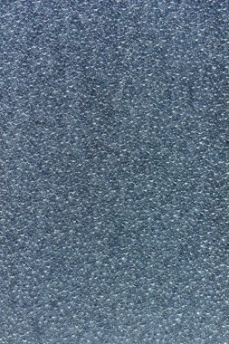 İnişli çıkışlı yüzeyini ve soyut desenini gösteren desenli buzlu camların detaylı bir yakın çekimi.