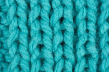 Dikey bir makro fotoğraf, ekstra kalın mavi iplikten örgü dokusunun detaylı bir yakın çekimini yakalar ve tüm çerçeveyi doldurur.