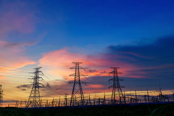 電気伝送パイロンは夕暮れ時青い空にシルエットで — ストック写真