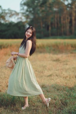Relaxed brunette girl walking on rice fields