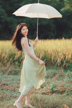 Relaxed brunette girl walking on rice fields