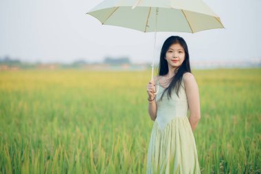 Relaxed brunette girl walking on rice fields