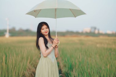 Relaxed brunette girl walking on rice fields