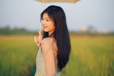 Relaxed brunette girl walking on rice fields