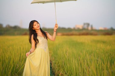Relaxed brunette girl walking on rice fields