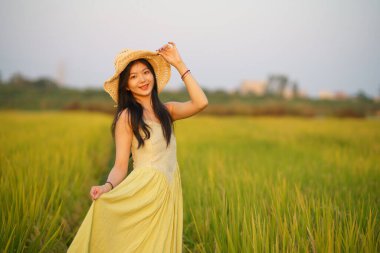 Relaxed brunette girl walking on rice fields