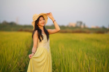 Relaxed brunette girl walking on rice fields