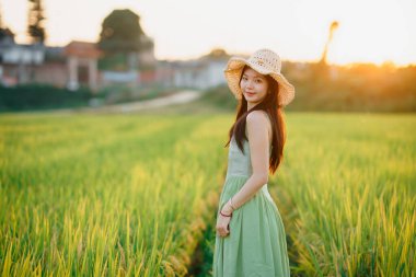 Relaxed brunette girl walking on rice fields