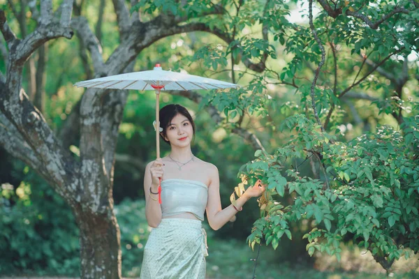 伝統的な中国のドレスの少女は庭にあります — ストック写真