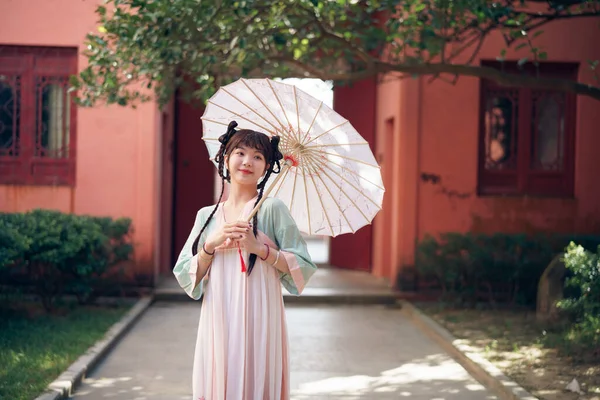 那位穿着中国传统服装的女孩在花园里 图库图片