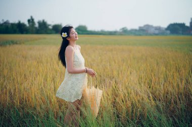 Relaxed brunette girl walking on rice fields