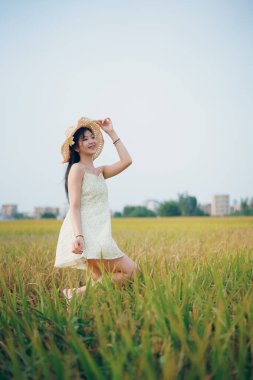 Relaxed brunette girl walking on rice fields