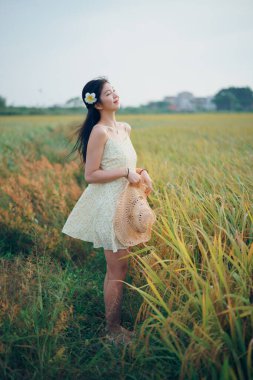 Relaxed brunette girl walking on rice fields