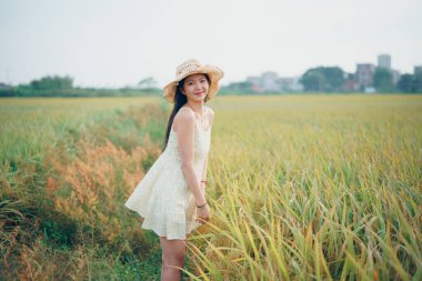 Relaxed brunette girl walking on rice fields