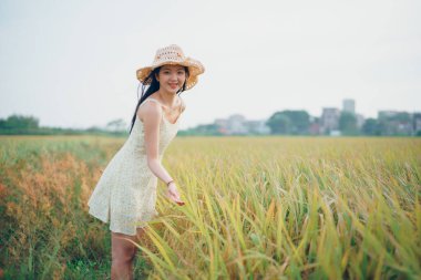 Relaxed brunette girl walking on rice fields