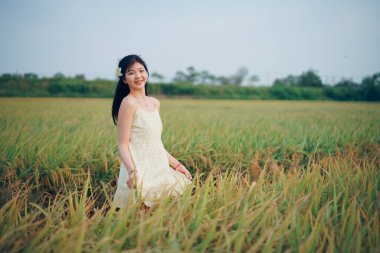 Relaxed brunette girl walking on rice fields