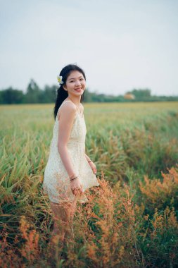 Relaxed brunette girl walking on rice fields