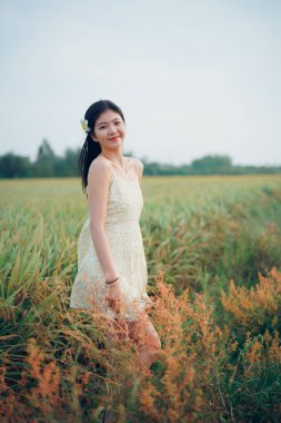 Relaxed brunette girl walking on rice fields