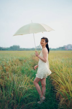 Relaxed brunette girl walking on rice fields
