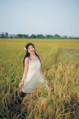 Relaxed brunette girl walking on rice fields