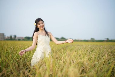 Relaxed brunette girl walking on rice fields