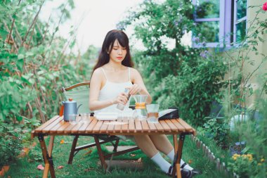 Kız avluda kahve yapıyor.