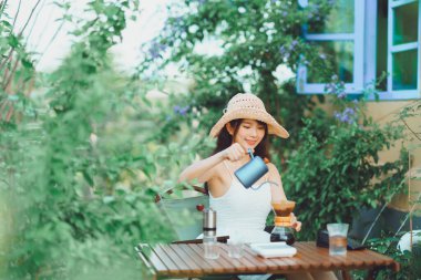 Kız avluda kahve yapıyor.