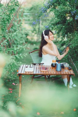 Asyalı kızlar kamp yaparken müzik dinlerler.