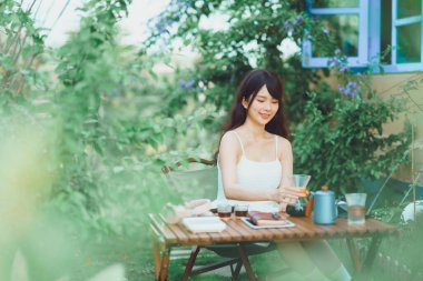 Kız avluda kahve yapıyor.