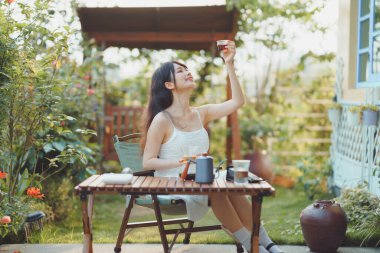 Kız avluda kahve yapıyor.