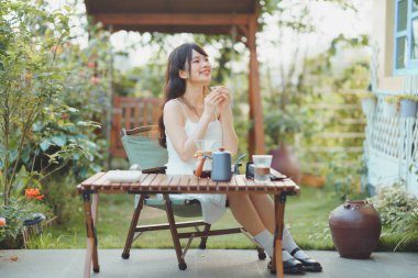 Kız avluda kahve yapıyor.