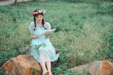 Kız büyük ağacın altında keman çalıyor.