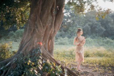 Nostaljik tema, ağacın altında flüt çalan kız.